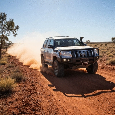 Modern 4x4 vehicle equipped with bull bar and snorkel navigating a dusty off-road trail